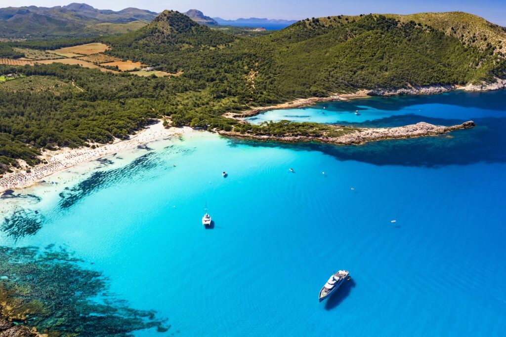 The Mallorca coast seen from the air, turquoise water below green hills